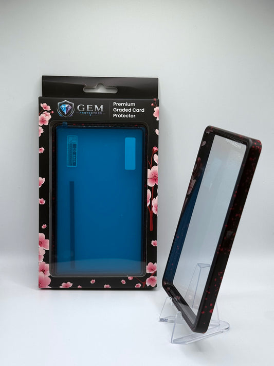 Red Speckle Gem Protectors case angled on a clear stand to show the frame's side profile, next to its retail box