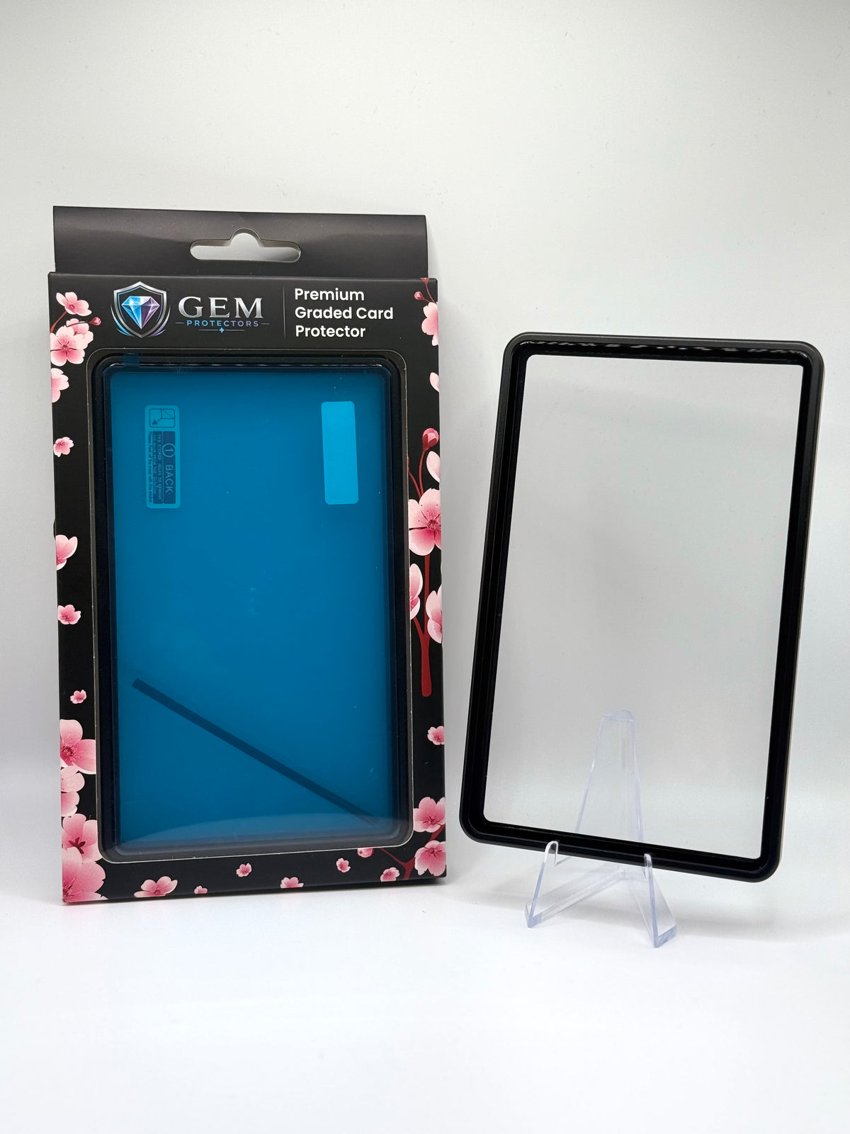 Front view of the empty Black Gem Protectors case showing the frame and clear panel, beside its retail box