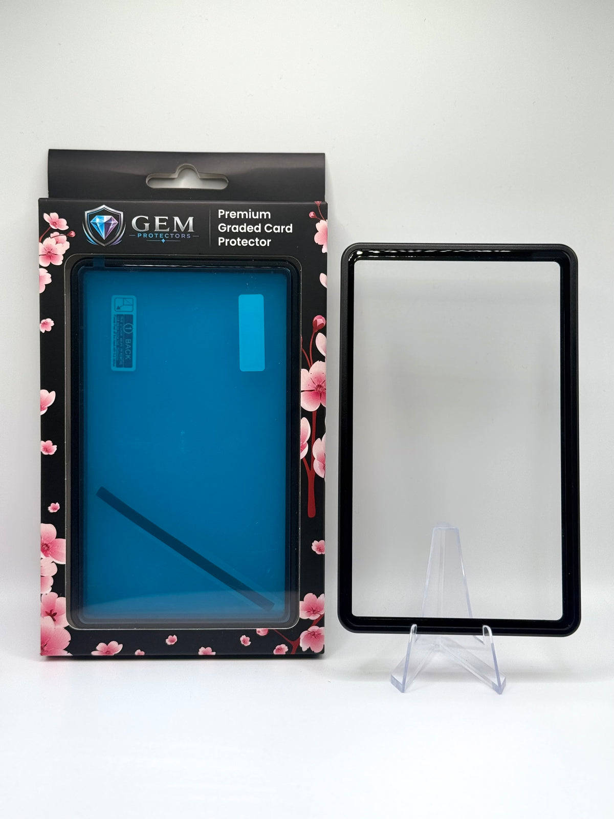 Black Gem Protectors magnetic PSA slab case standing upright on a clear stand next to its retail box
