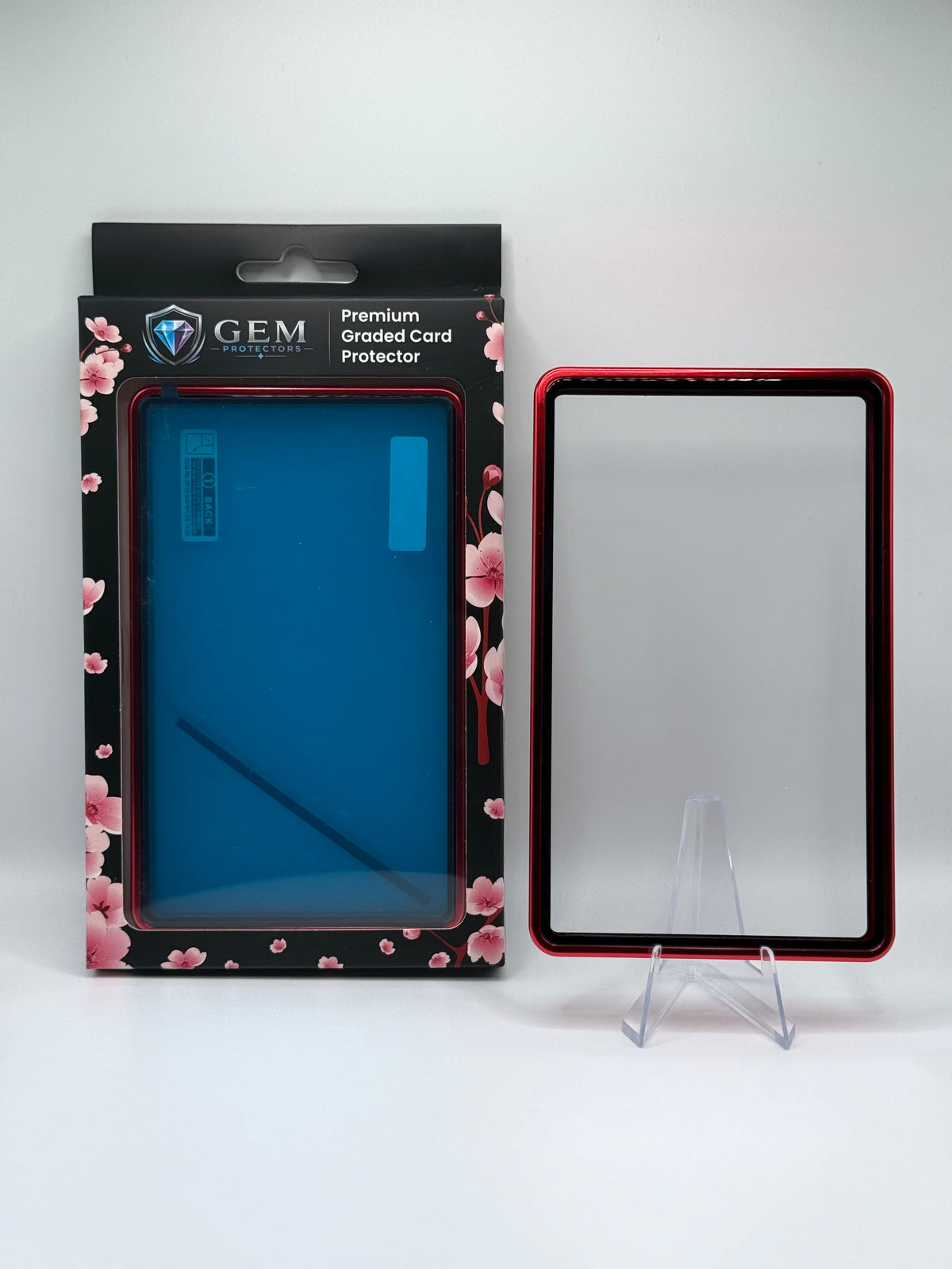 Red Gem Protectors magnetic PSA slab case standing upright on a clear stand next to its retail box