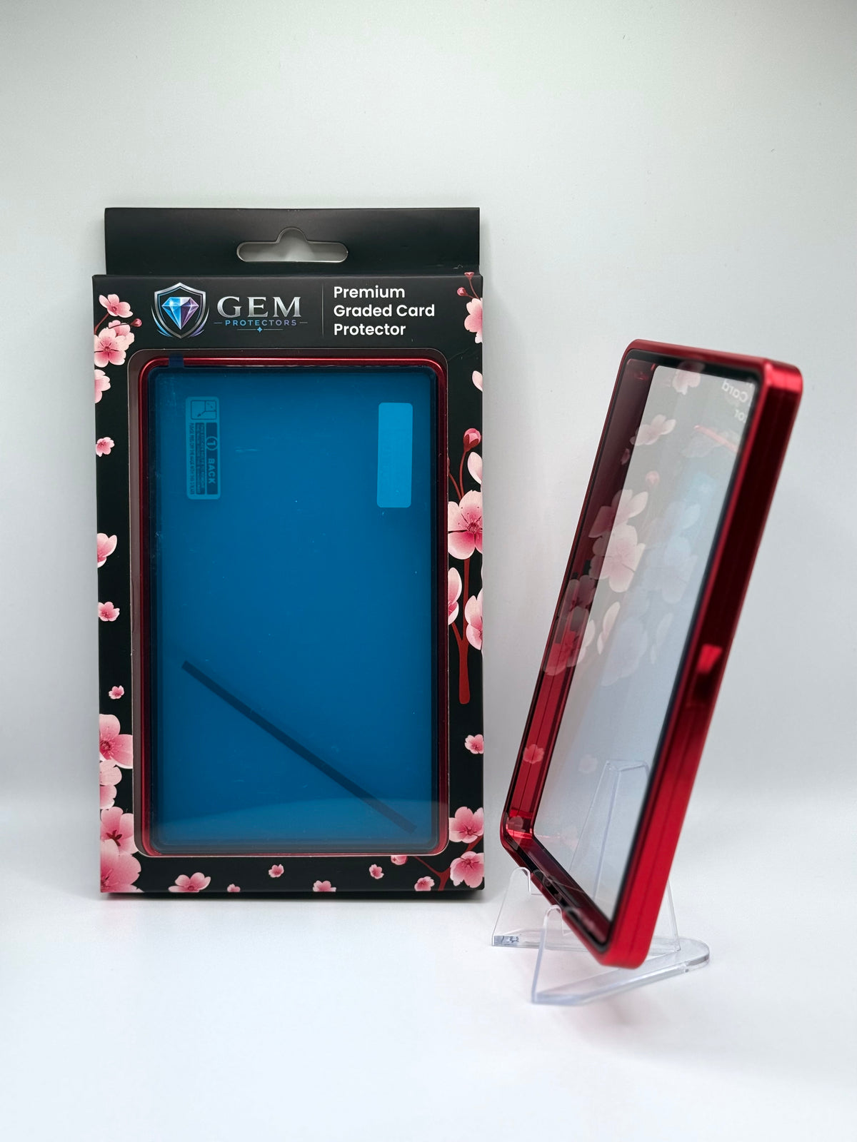 Red Gem Protectors case angled on a clear stand to show the frame's side profile, next to its retail box