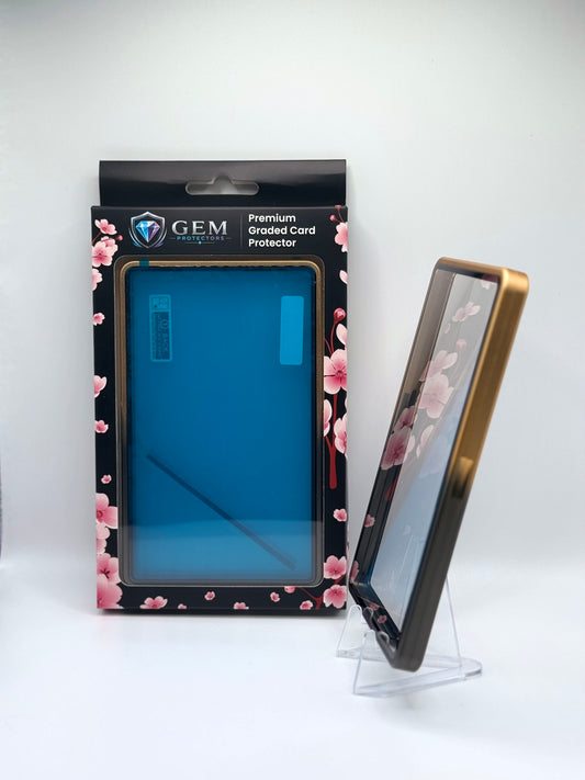 Black & Gold Gem Protectors case angled on a clear stand to show the frame's side profile, next to its retail box