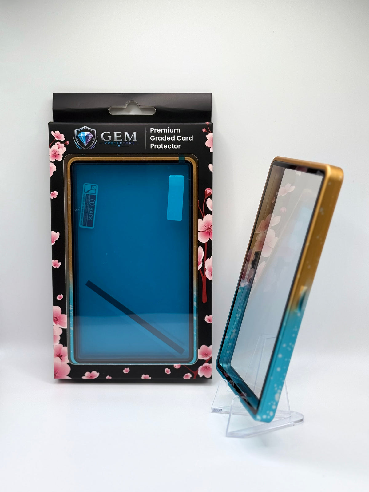 Blue & Yellow Sparkle Gem Protectors case angled on a clear stand to show the frame's side profile, next to its retail box