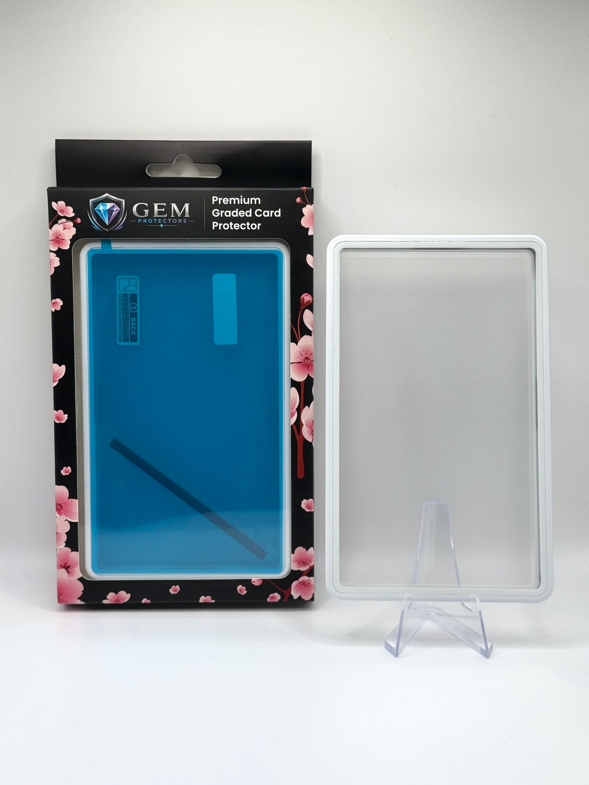 Porcelain White Gem Protectors magnetic PSA slab case standing upright on a clear stand next to its retail box