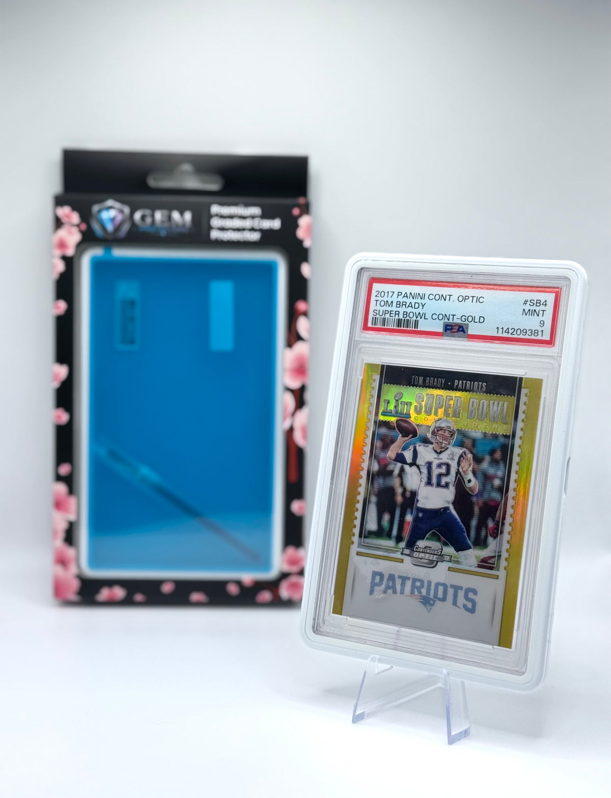Porcelain White Gem Protectors case holding a PSA-graded Tom Brady Patriots card, shown beside its retail box
