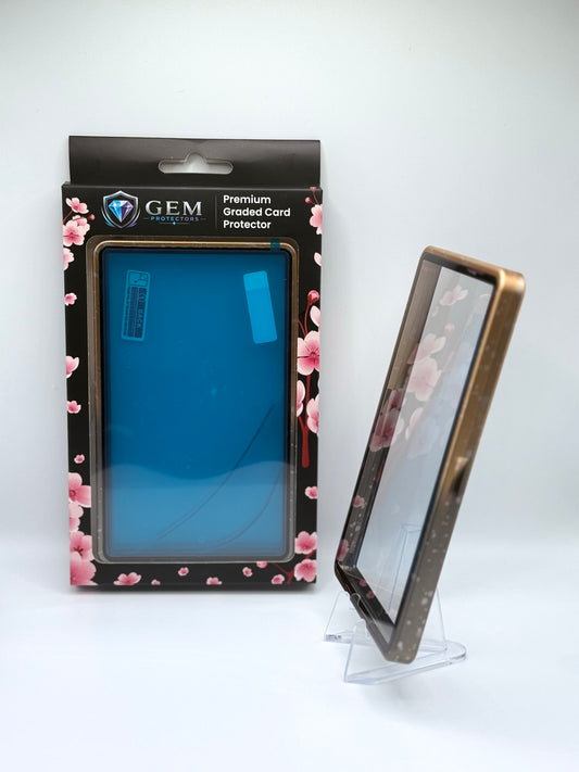 Black & Gold Speckle Gem Protectors case angled on a clear stand to show the frame's side profile, next to its retail box