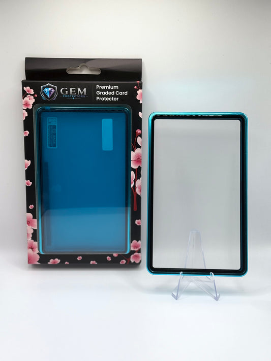 Teal Gem Protectors magnetic PSA slab case standing upright on a clear stand next to its retail box