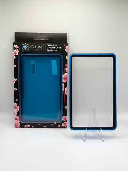 Deep Blue Gem Protectors magnetic PSA slab case standing upright on a clear stand next to its retail box