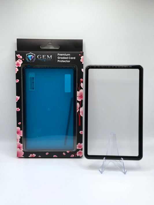 Charcoal Gray Gem Protectors magnetic PSA slab case standing upright on a clear stand next to its retail box