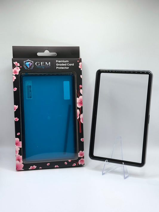 Front view of the empty Charcoal Gray Gem Protectors case showing the frame and clear panel, beside its retail box