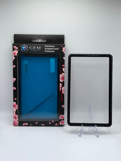 Blue Speckle Gem Protectors magnetic PSA slab case standing upright on a clear stand next to its retail box