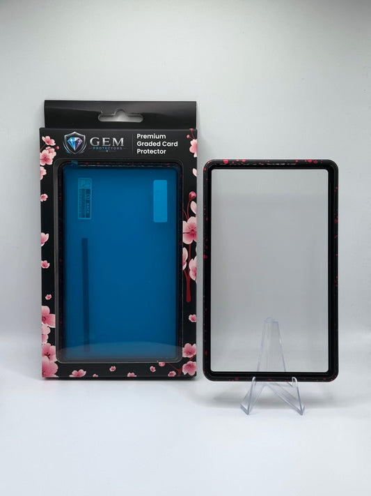 Red Speckle Gem Protectors magnetic PSA slab case standing upright on a clear stand next to its retail box