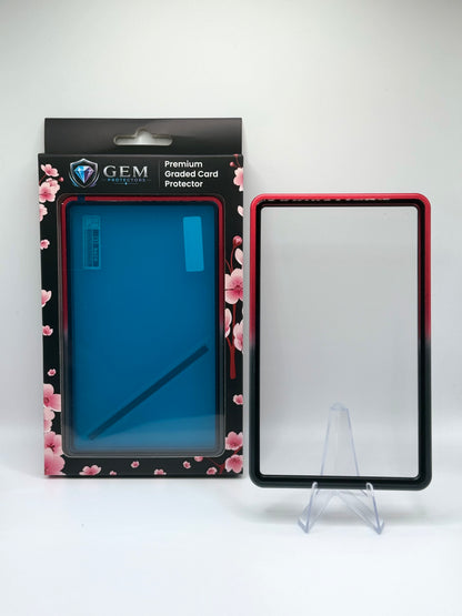 Black & Red Gem Protectors magnetic PSA slab case standing upright on a clear stand next to its retail box